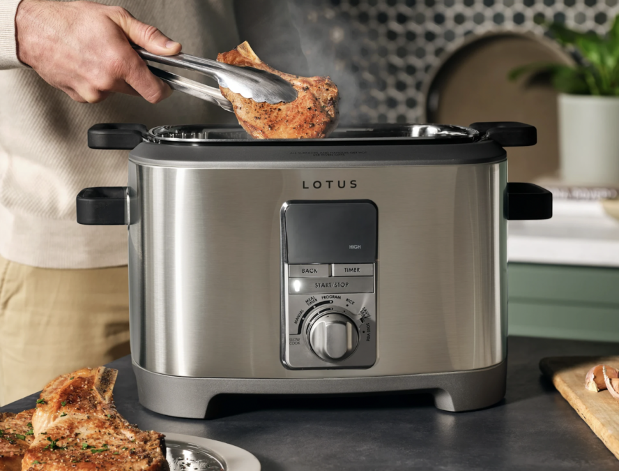 Image of the Lotus The Sous Mult-Function Cooker with a pair of hands pulling meat out.