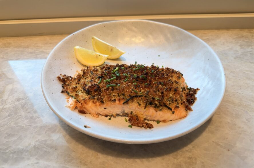 Image of a plate of two parmesan-garlic air fryer salmon fillets.