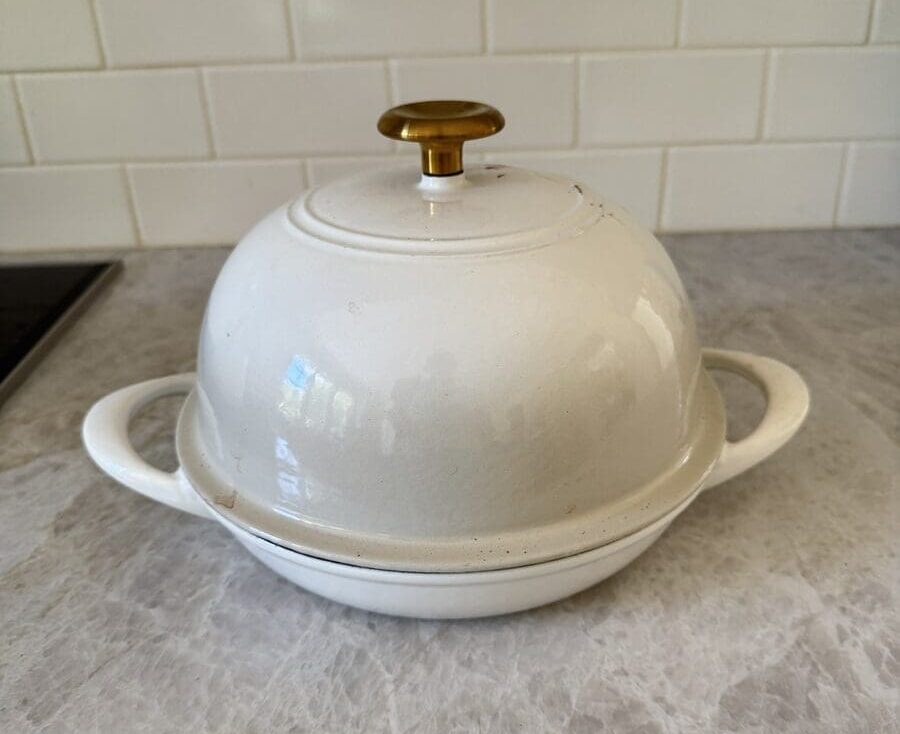 Image of a Tramontina bread oven in Latte, shown on a white marble countertop.