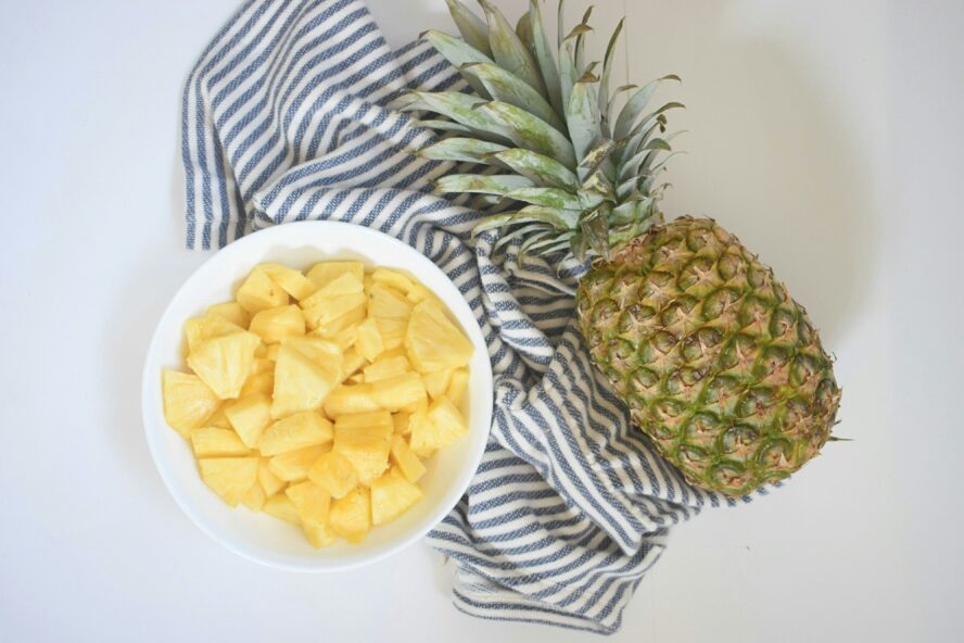 caramelized grilled pineapple spears on a white plate with deep grill marks and a golden sugar crust
