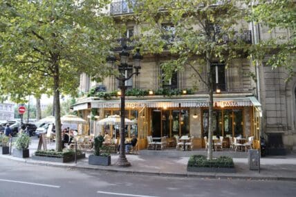 Image of a group of people sitting at an outdoor seating in a French restaurant.