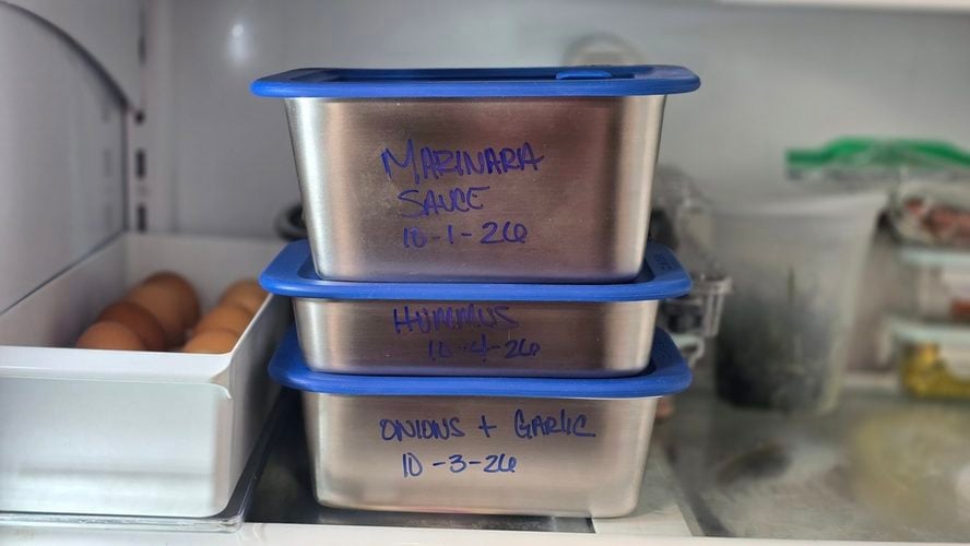 Image of three Misenware containers stacked on top of each other in the freezer, labeled directly on the stainless steel with a blue marker.