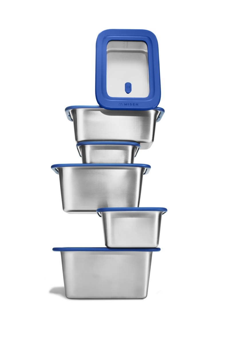 Image of Misenware stainless steel food storage containers stacked haphazardly.