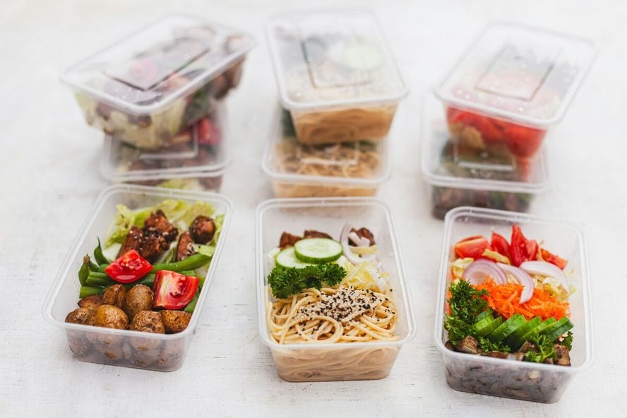 Image of several plastic food storage containers full of food and stacked on top of each other.