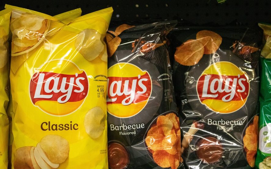 Image of several bags of Lay's potato chips shown on a shelf.